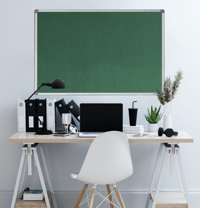 Green velour fabric pinboard above a home office desk