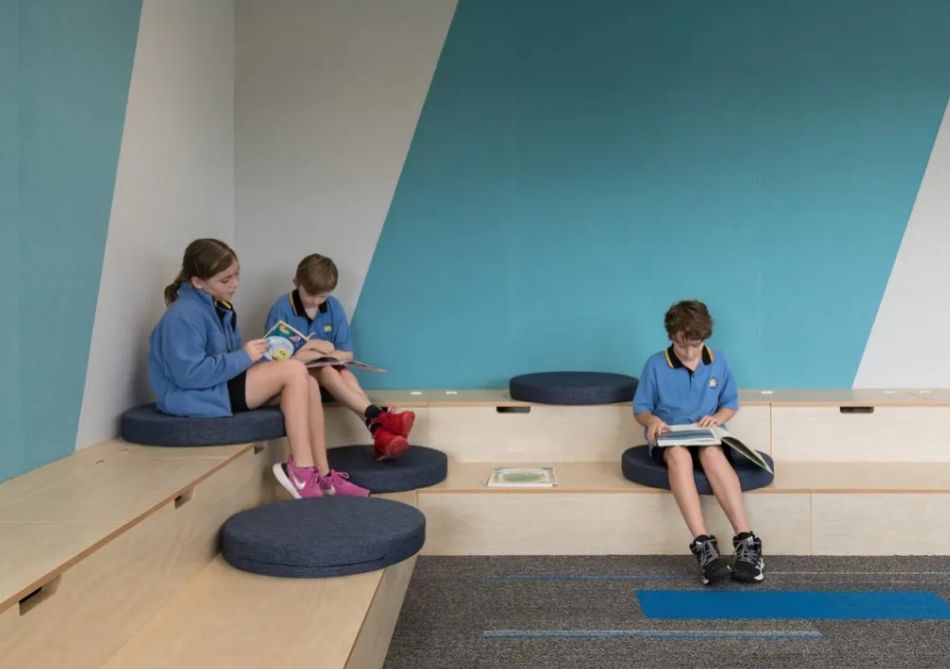 Composition acoustic fabric panels in a school reading nook