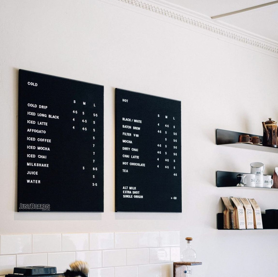 Two black changeable letter menu boards in a cafe