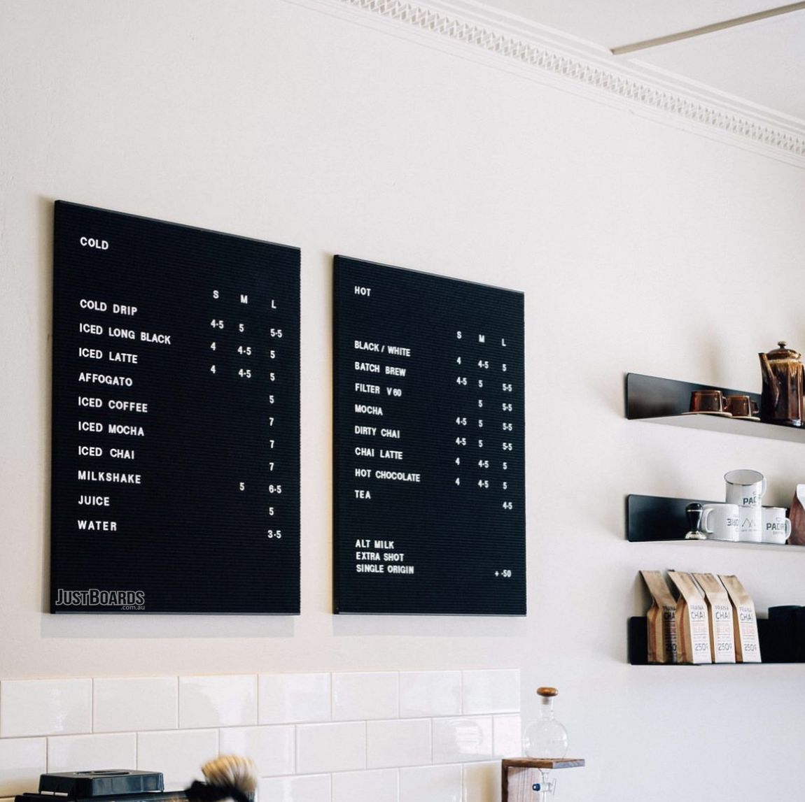 Two black changeable letter menu boards in a cafe