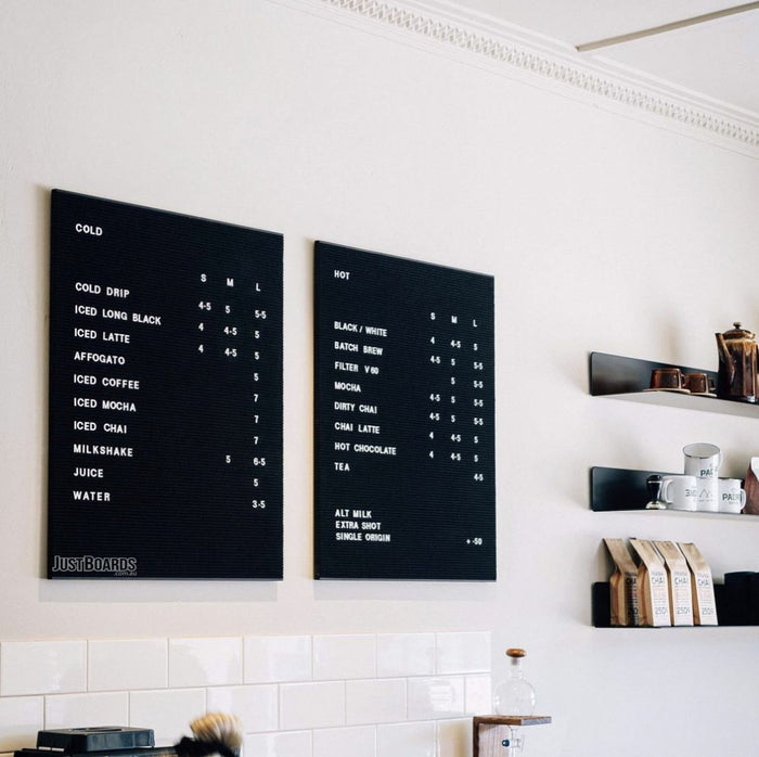 Two black changeable letter menu boards in a cafe